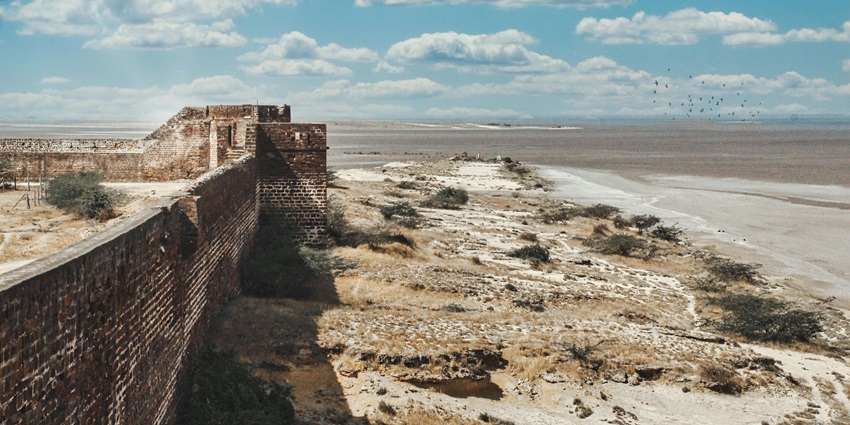 A scenic road leading to the Pyramid of Djoser, framed by the vast desert and ancient ruins.