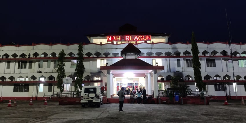 Naharlagun railway station with a white building and a car parked outside the station.
