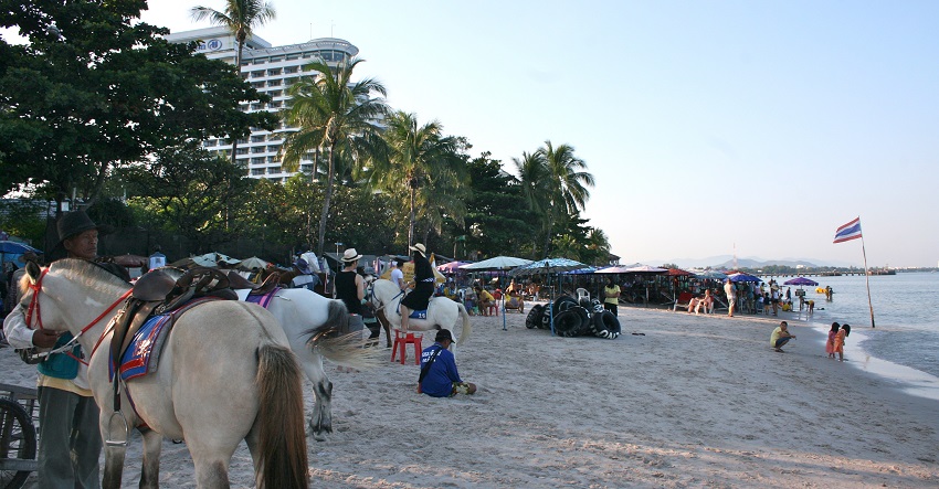 The beautiful Hua Hin Beach has golden sand and blue waters, and people enjoy water sports.