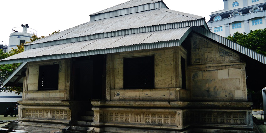 A historic coral-stone mosque in Malé, showcasing intricate carvings and Islamic architecture.