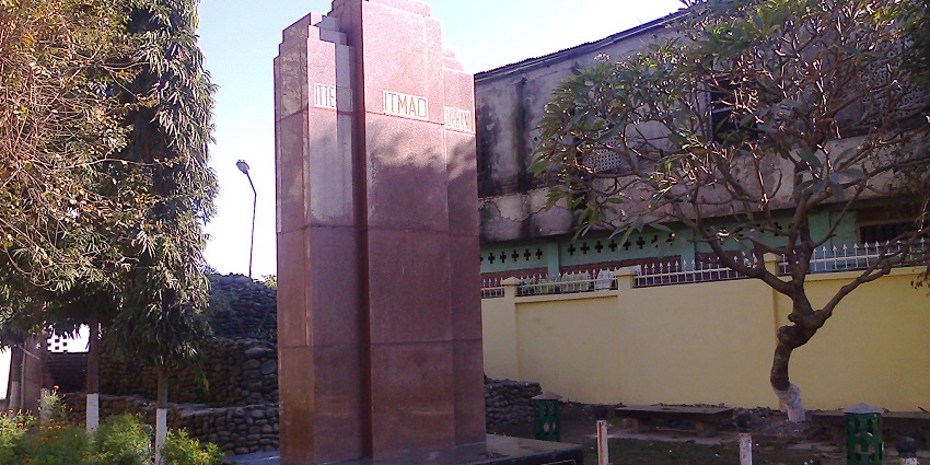 INA memorial complex with multiple signages on the base of a red stone and unique flowers.