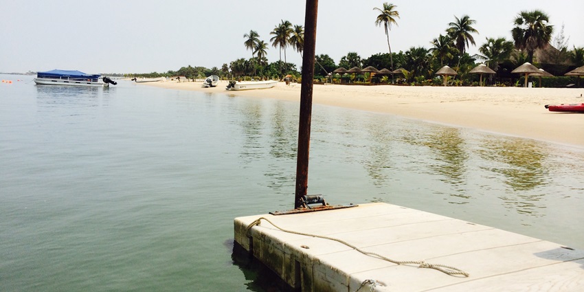 Peaceful view of Ilha do Mussulo with calm blue water and palm-lined shoreline
