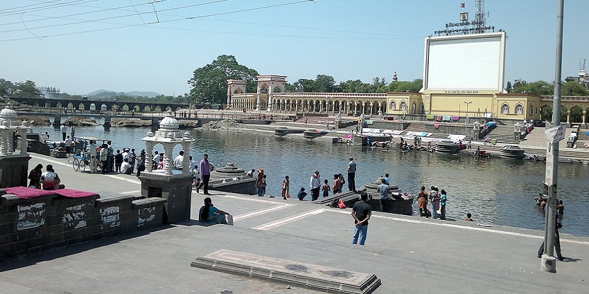 Image of the Indrayani River Ghat and people around the ghat strolling around during day time view