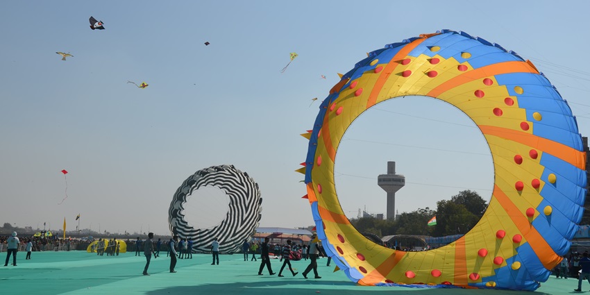 An image showing the International Kite Festival in India with colourful kites filling the sky.