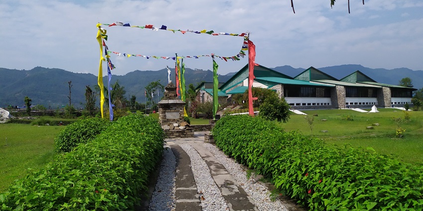 Pathway with flags leading to the International mountain museum surrounded by greenery