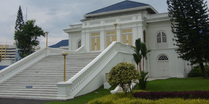 An image of an ornate white building of Istana Besa, with a blue roof, columns and sky.