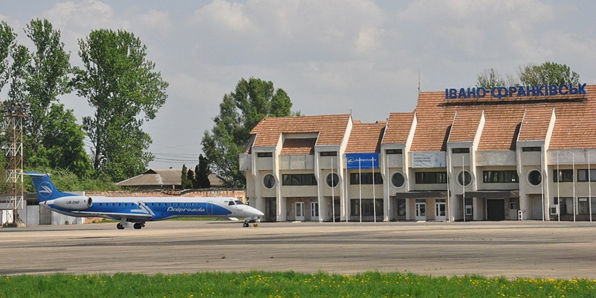 Ivano-Frankivsk International Airport with a scenic jungle backdrop and an aeroplane parked on the left