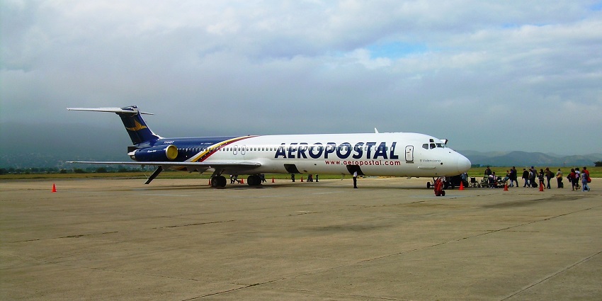 An MD-82 is boarding at Jacinto Lara International Airport with passengers carrying luggage