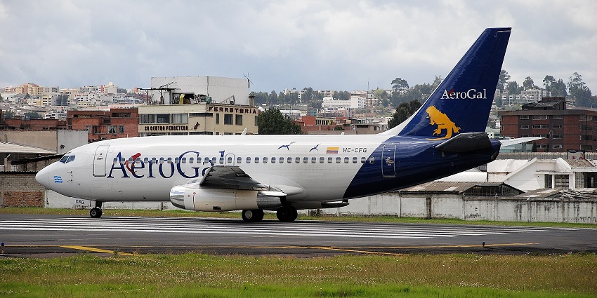 Aeroplane parked at the runway of Jaime Gonzalez Airport with buildings in the back