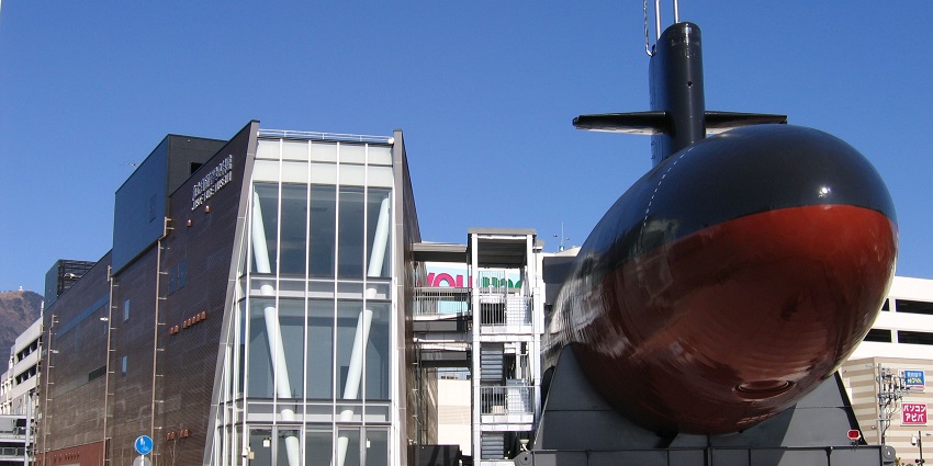 An image of a black submarine with a red underside displayed outdoors at Japan Maritime Self-defence Force Museum.