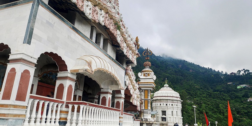 Jatoli temple corridor with traditional architecture, intricate carvings and saffron flags