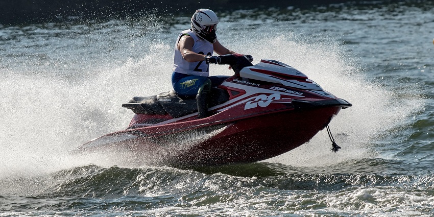 A man riding a jet ski through waves at Baga Beach, Goa