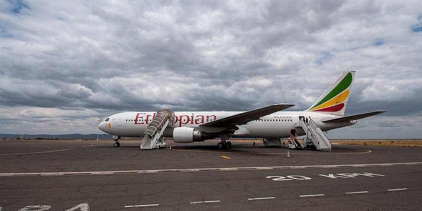 Ethiopian Airlines plane parked on the tarmac with a cloudy sky in Jijiga Airport in Ethiopia.