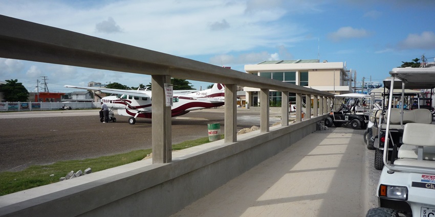 John Greif II airport with a small propeller aircraft in the airport and multiple vehicles