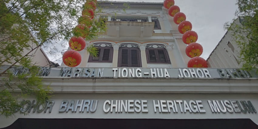 ohor Bahru Chinese Heritage Museum with red lanterns, signage, trees, and classic design.