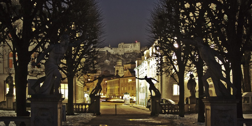 Image of two sculptures joining hands together from across the street to form a gate like structure