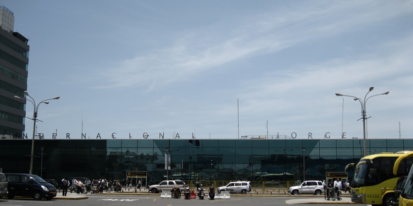 Jorge Chávez International Airport with glass architecture, many cars and buses parked, and bustling passengers