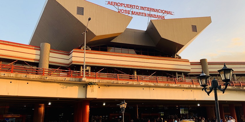 Terminal building of José Martí International Airport with vehicles parked and people