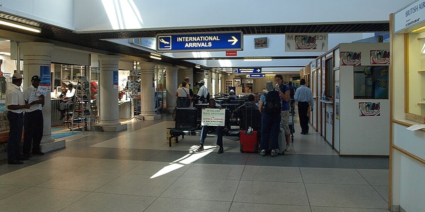 Inside view of an international airport terminal with passengers, check-in counters, and seating areas