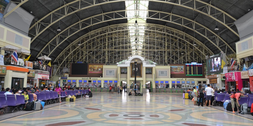 Passengers are busy walking in the airport terminal carrying luggage and bags.