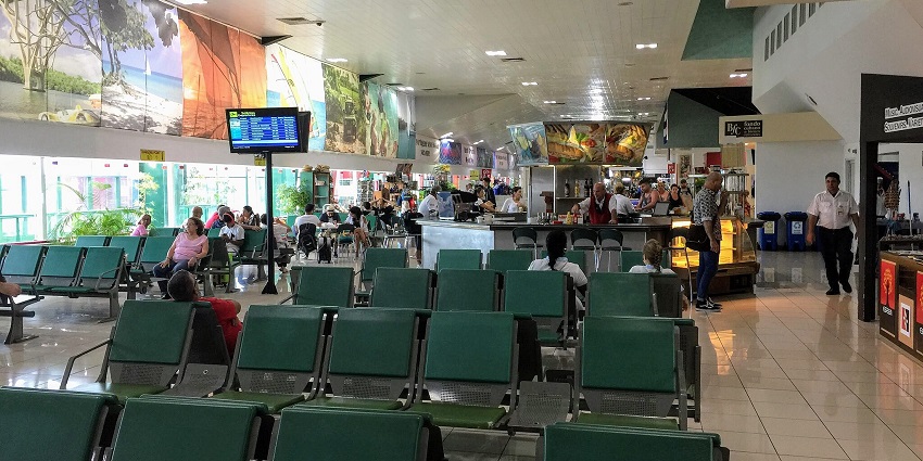 Waiting area of the Juan Gualberto Gómez International Airport with passengers and a store