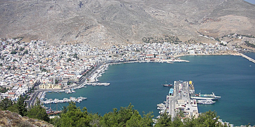 Kalymnos, Greece, with white buildings, a harbour, a blue sea, and a mountainous backdrop