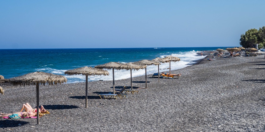 Kamari Beach, one of the stunning black sand beaches in the world, offers breathtaking views.