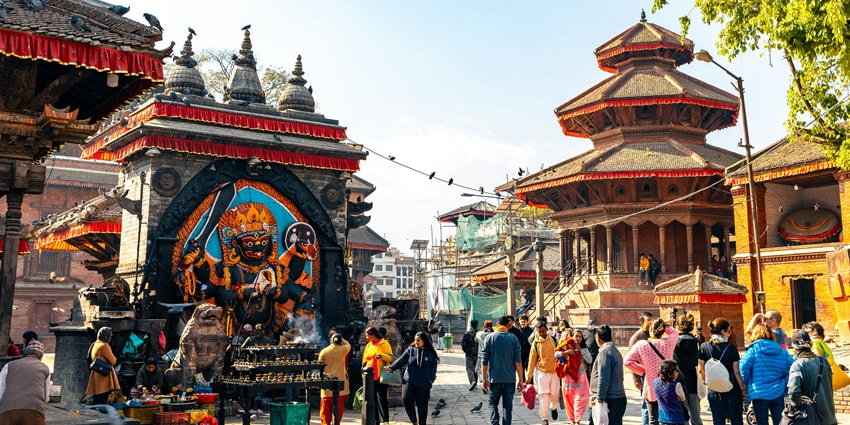 A glimpse of the towering Kathmandu Durbar Square in Nepal bustling with people.