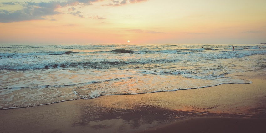 Image of peaceful morning at Kedonganan Beach with gentle waves and golden sunlight.