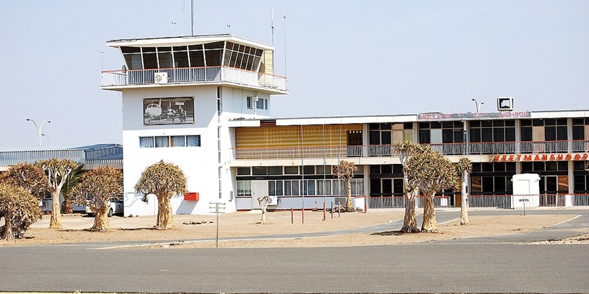 Keetmanshoop Airport’s terminal is standing under bright sunshine and small trees