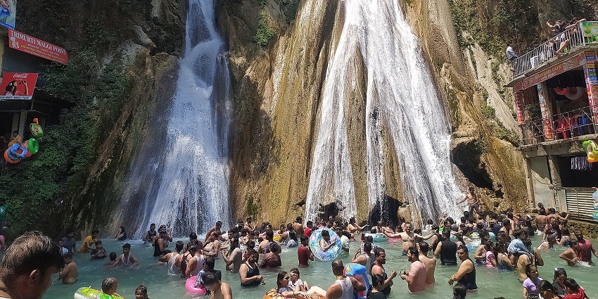 Image of people swim near this waterfalls located near the temple