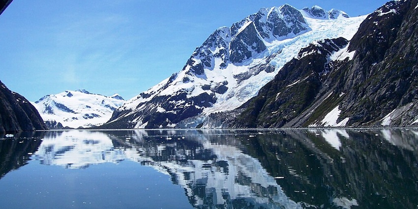 A photo of the glacier in Kenai Fjords National Park, Alaska, with icy waters and a mountainous backdrop.