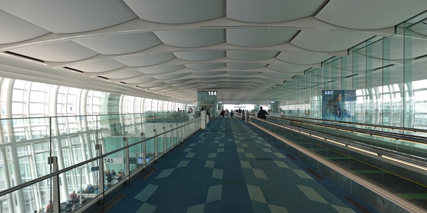 The interior view of a modern-designed international airport is covered with glass.