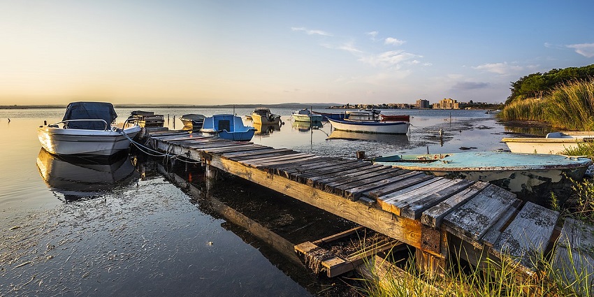 Empty boats docked near the banks of a lake during a beautiful sunrise in Bikaner, India.
