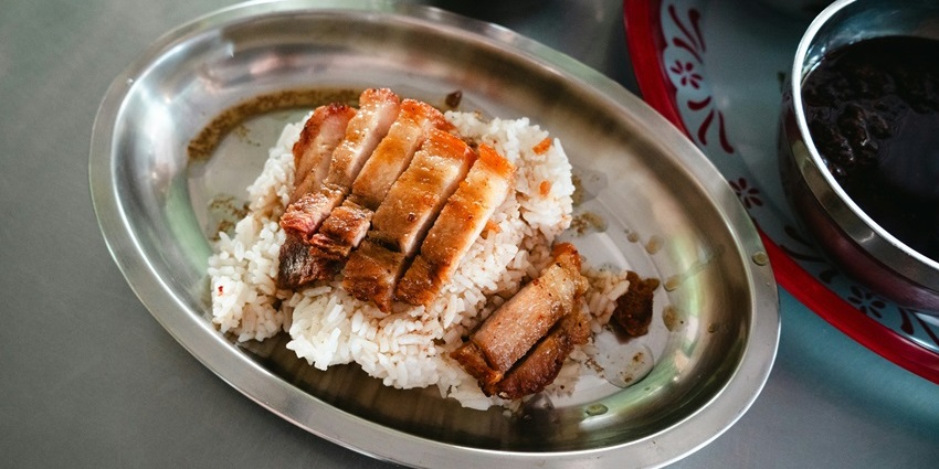 Image of rice and pork served on a small plate in a restaurant - enjoy the Khao Kan Jin