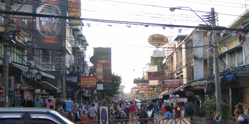 A photograph of Khao San Road in Bangkok, filled with pulsating nightlife, street food vendors, and stores.
