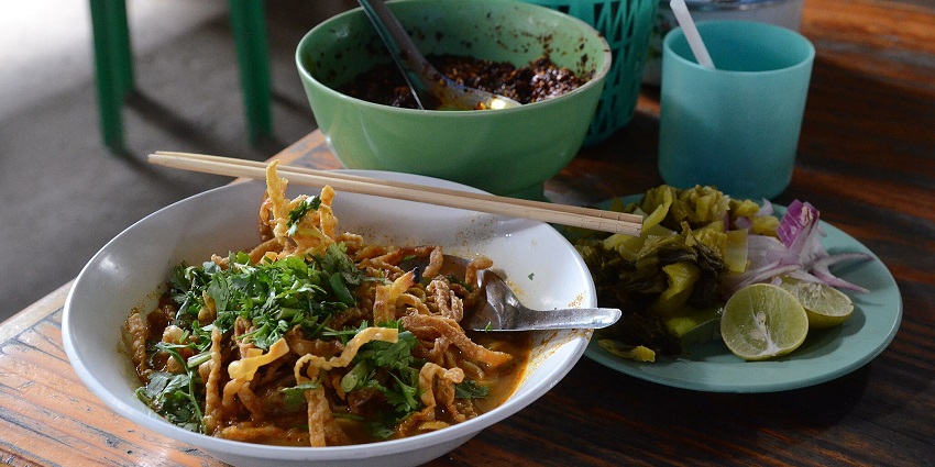 Chiang Mai local dish with deep-fried and cooked egg noodles in coconut curry, topped with meat