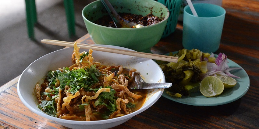 An image of the northern Thai coconut curry noodle soup topped with crispy noodles.
