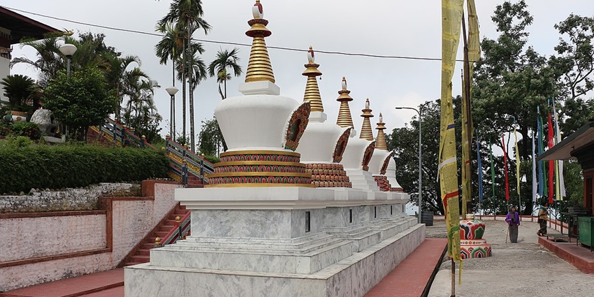 View of stupas at the beautiful Kharbandi Gompa, surrounded by lush trees