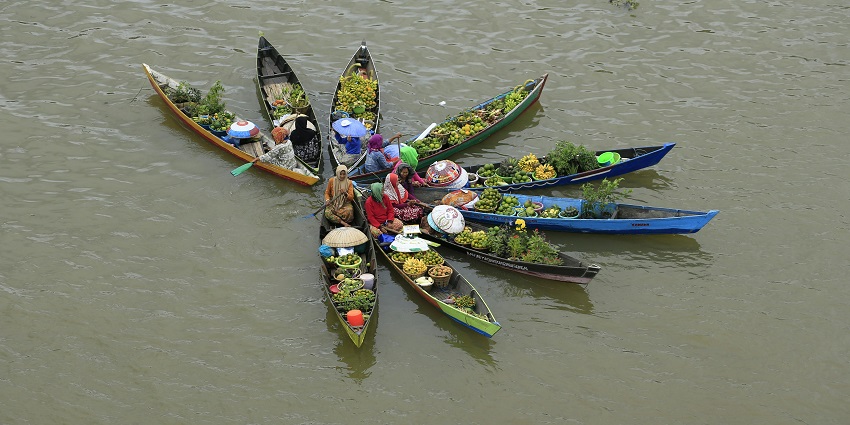 A view of vendors in traditional hats selling goods at Khlong Lat Mayom in Thailand.