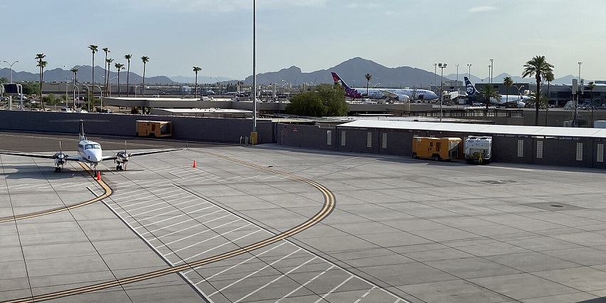 Several aircraft on the runway with a clear sky at one of the major airports in Iraq.