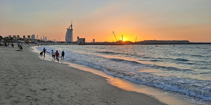An image of people enjoying the stunning sunset view and shoreline of the Kite Beach