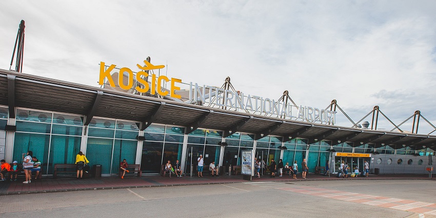 People sitting on benches wait outside the Košice International Airport in Slovakia.