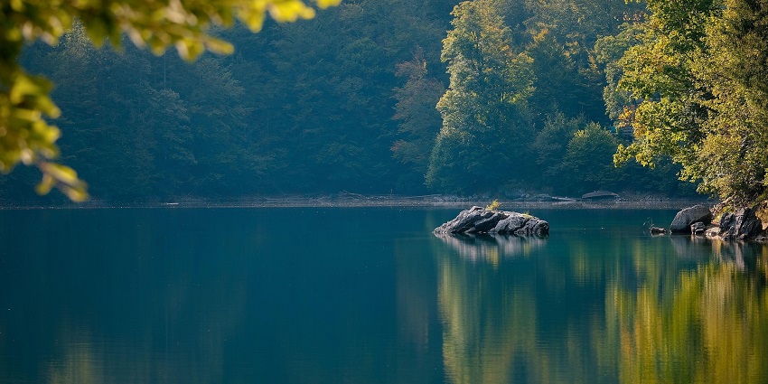 An image of a lake surrounded y lush greenery - Kukas Lake surrounded by green hills