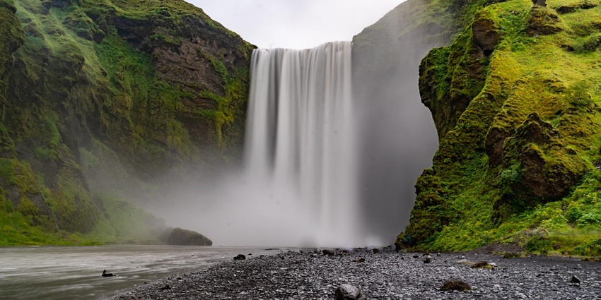 An image showing a waterfall cascading down a cliff into a river, similar to Kunchikal Falls.