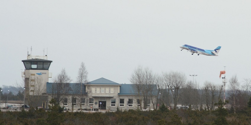 Estonian Air Saab taking off at Kuressaare Airport terminal with trees in the foreground