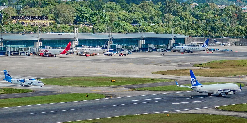 La Aurora International Airport terminal with parked planes and adjacent taxiways.