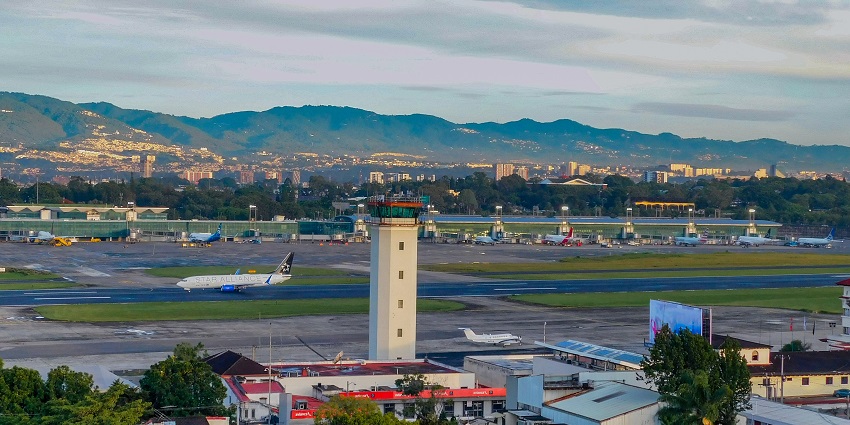 Top view of La Aurora International Airport showing runways, planes, terminal buildings.