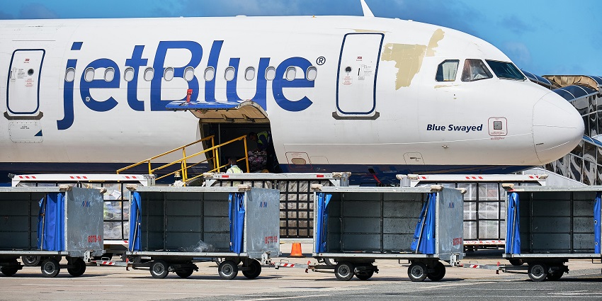 A large JetBlue plane parked at an airport, one of the airports in Dominican Republic.