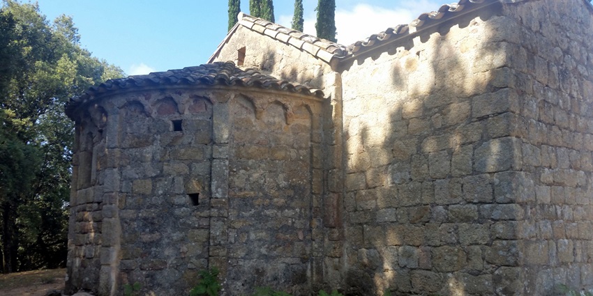 An ancient stone structure is standing quietly in nature while sunlight is falling gently.